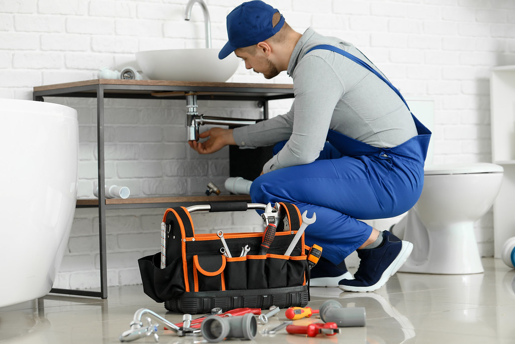 Técnico fontanero resolviendo una avería en baño